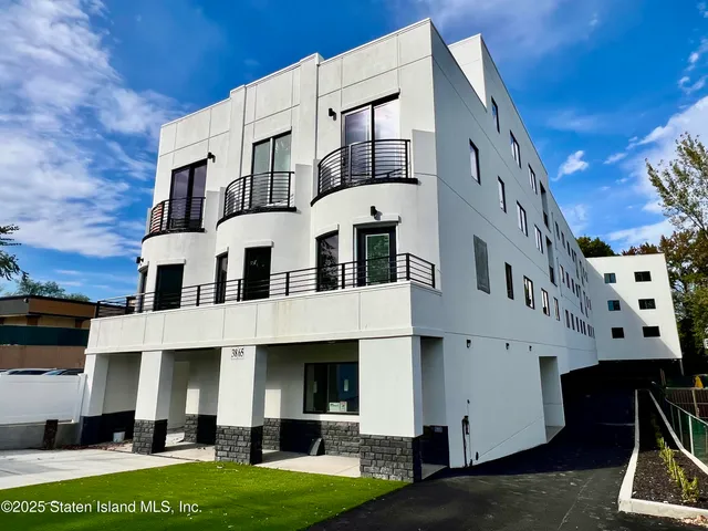 a front view of a building with a garden