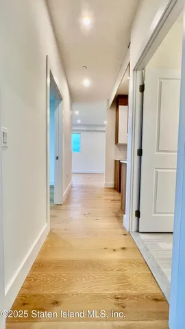a view of a hallway with wooden shelves