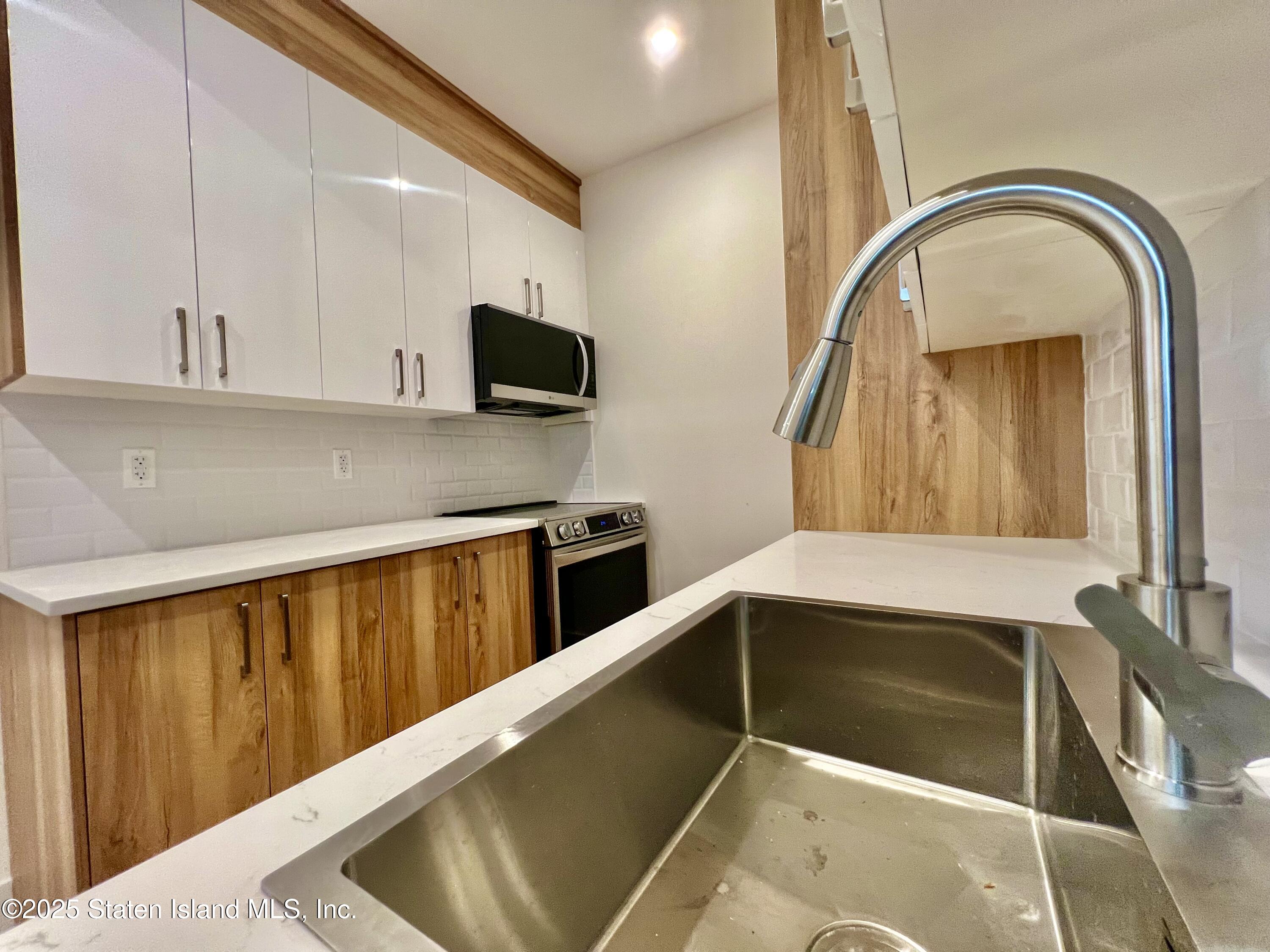3865 Amboy Road, Unit 2G Staten Island, NY 10308 - Photo 12 of 27 a kitchen with a sink and a microwave