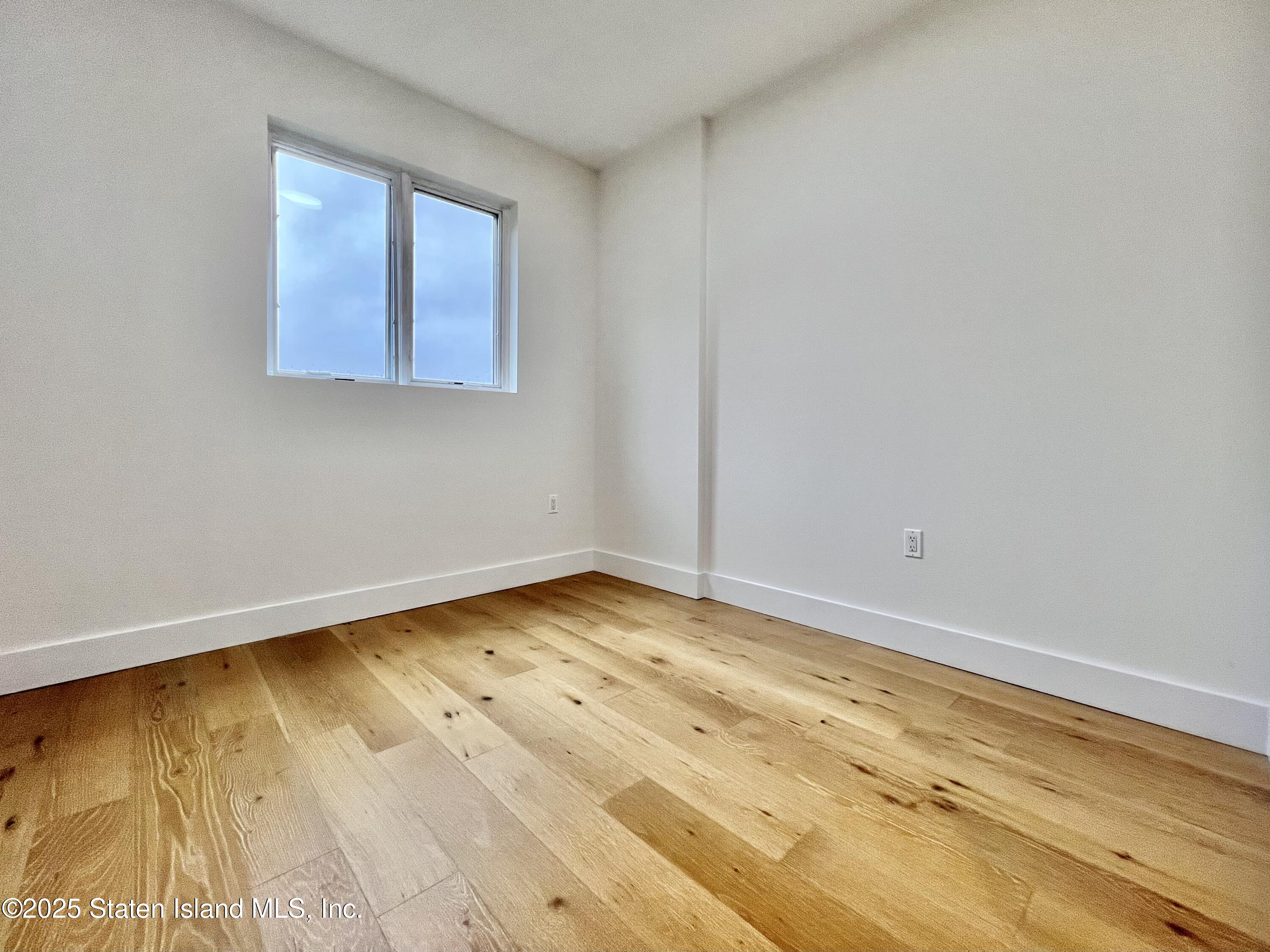 3865 Amboy Road, Unit 2G Staten Island, NY 10308 - Photo 21 of 27 a view of empty room with wooden floor and fan