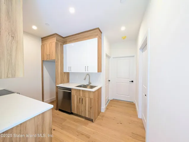 a view of a kitchen with a sink cabinets and wooden floor