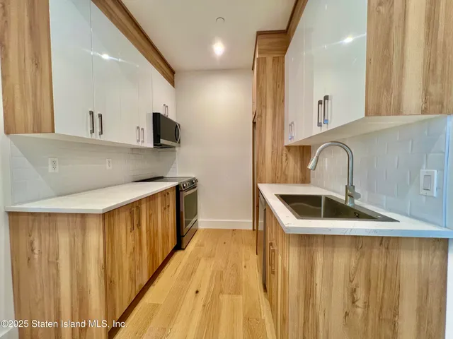 a kitchen with stainless steel appliances a sink and a refrigerator