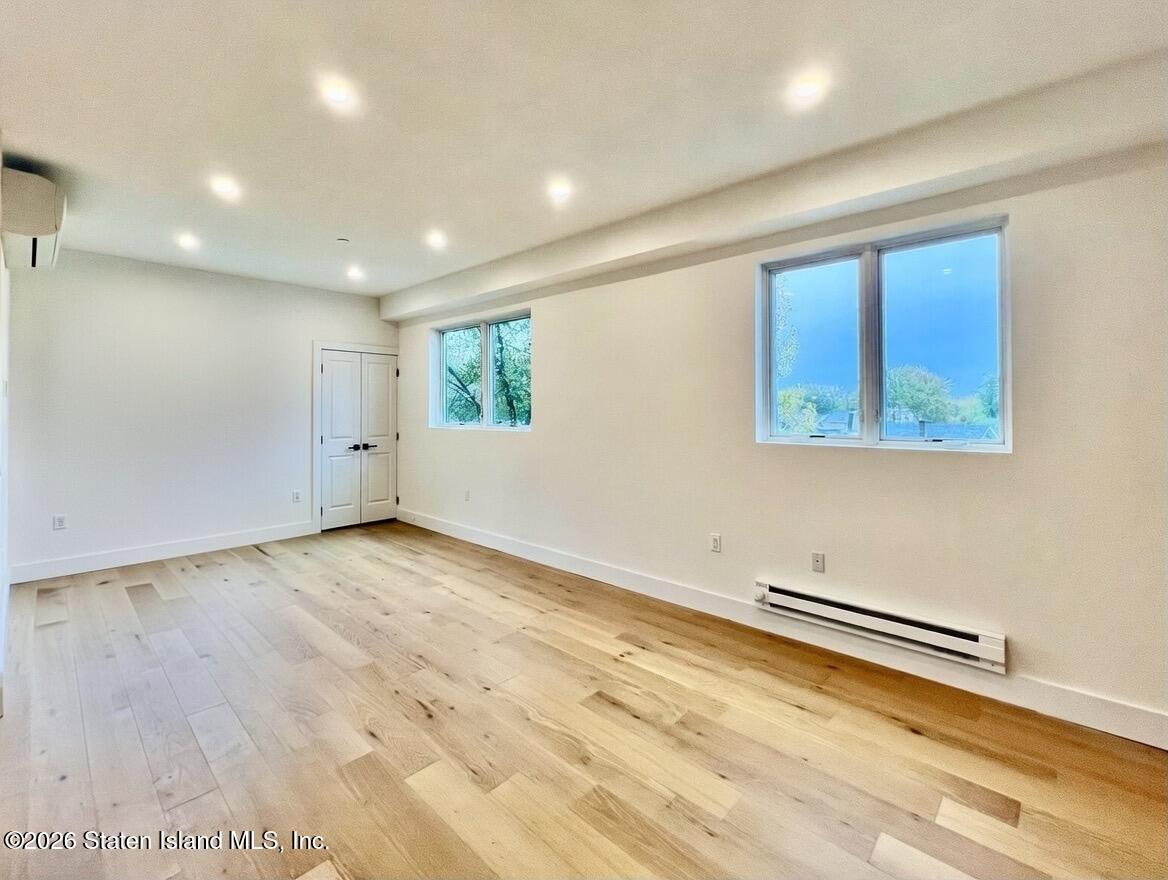 3865 Amboy Road, Unit 2G Staten Island, NY 10308 - Photo 8 of 27 an empty room with wooden floor and windows