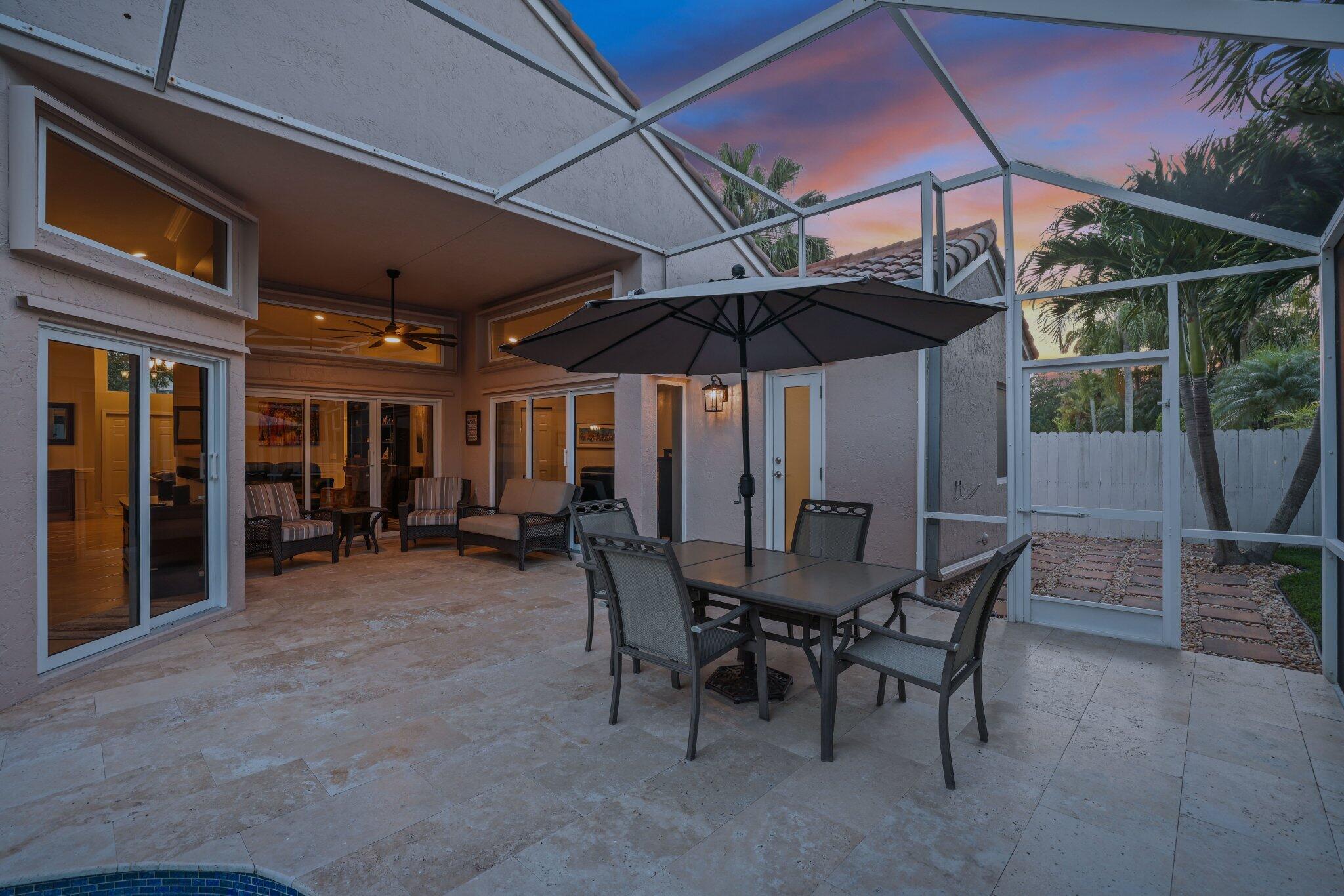 116 Cameron Drive Weston, FL 33326 - Photo 56 of 75 a view of a patio with a table and chairs under an umbrella