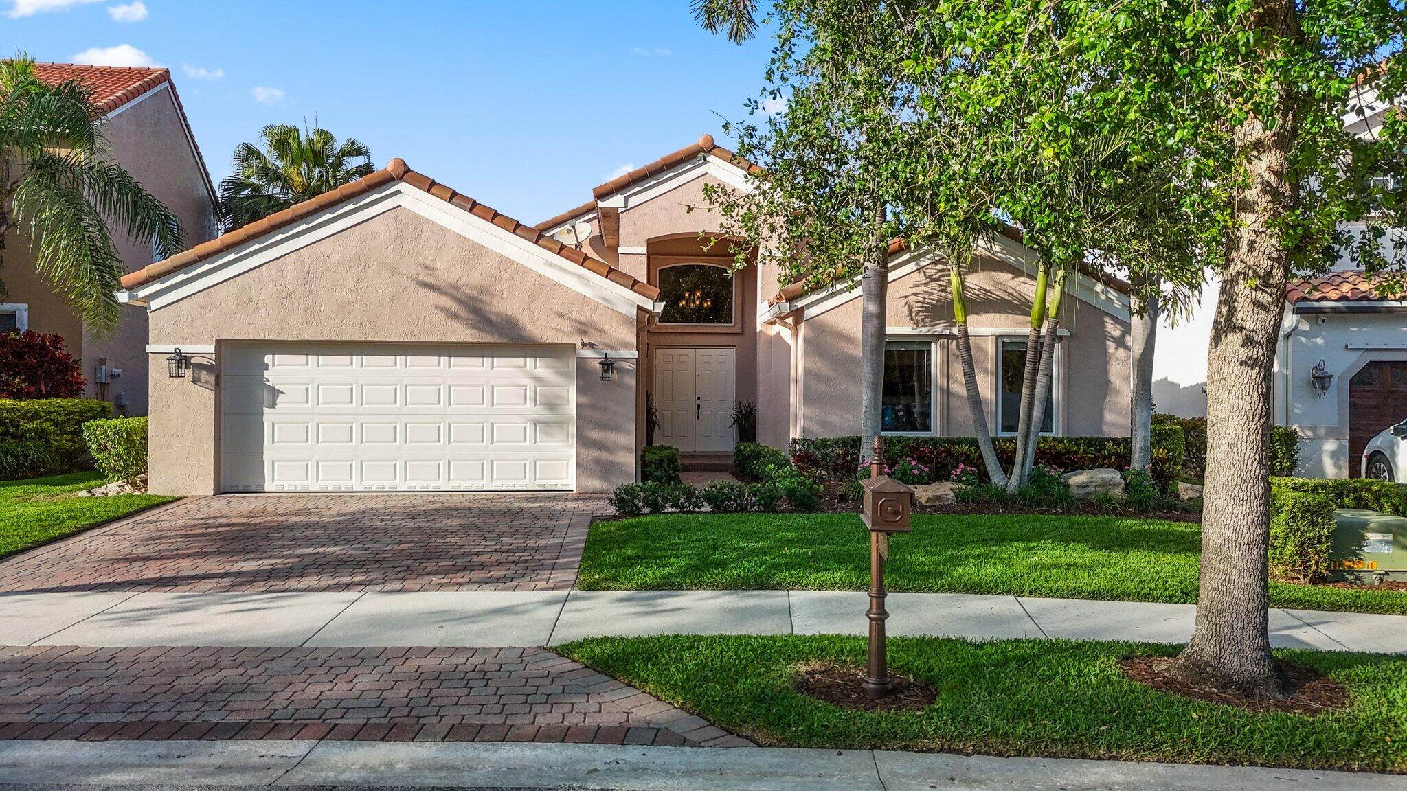 116 Cameron Drive Weston, FL 33326 - Photo 64 of 75 a front view of a house with a yard and garage