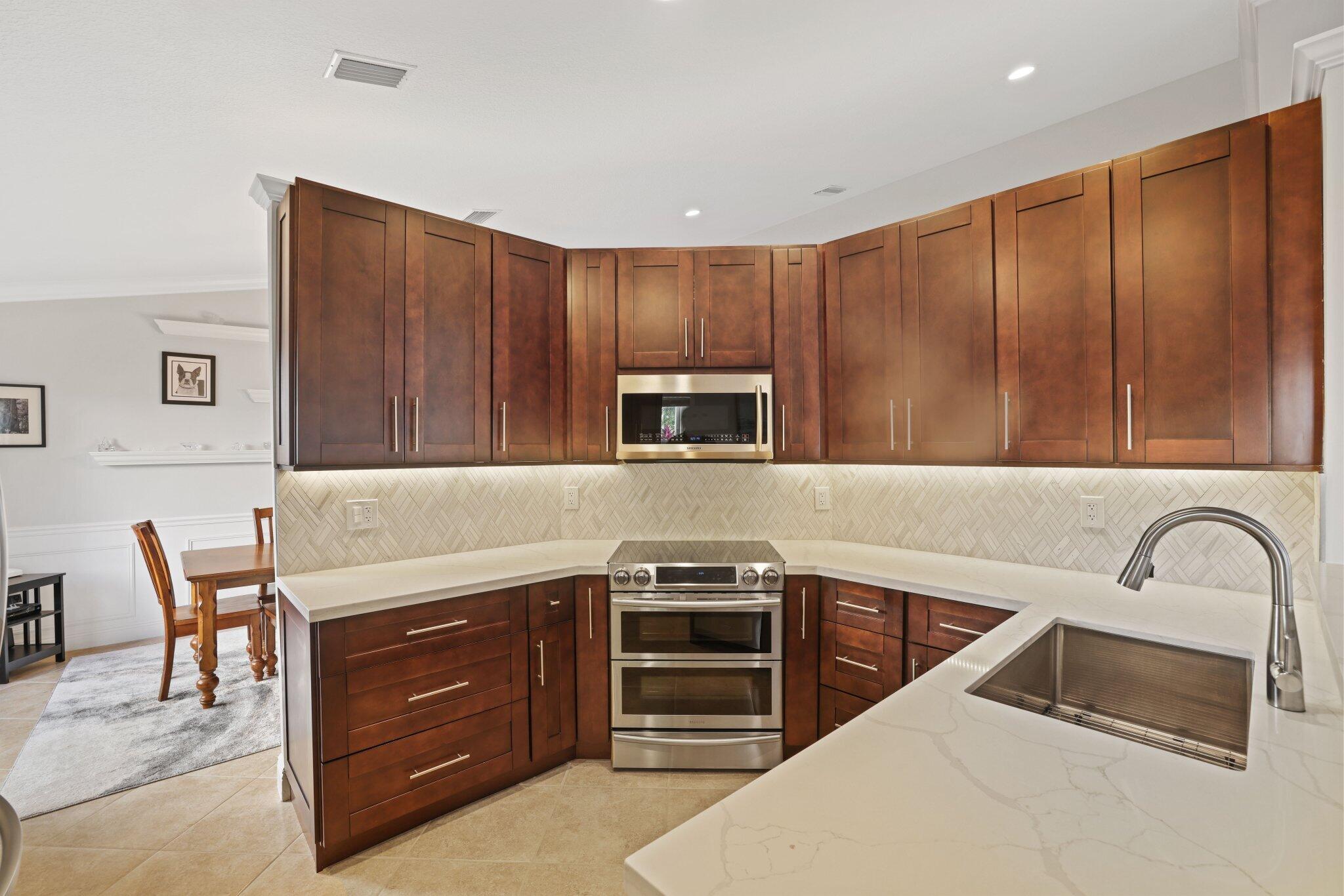 116 Cameron Drive Weston, FL 33326 - Photo 9 of 75 a kitchen with stainless steel appliances a stove sink and microwave