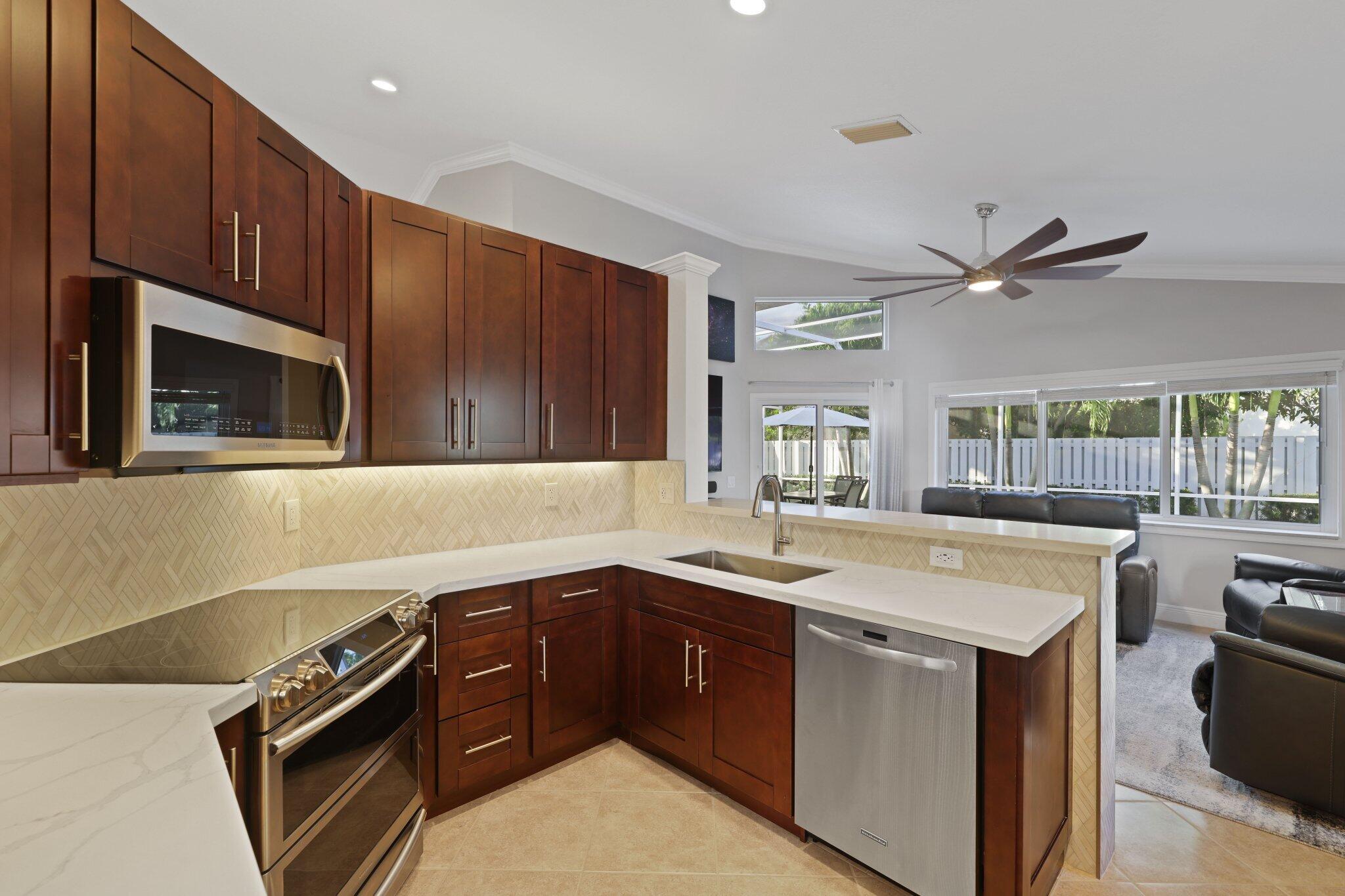 116 Cameron Drive Weston, FL 33326 - Photo 10 of 75 a kitchen with a sink stove and microwave