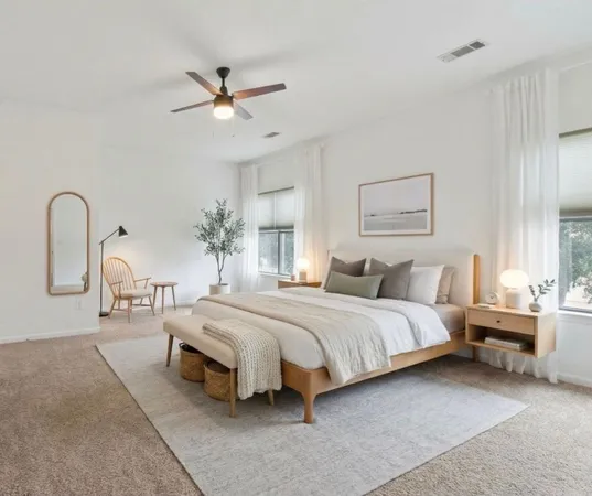 a spacious bedroom with a bed a large window with a chandelier