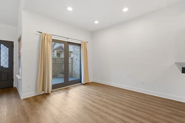 an empty room with wooden floor and mirror