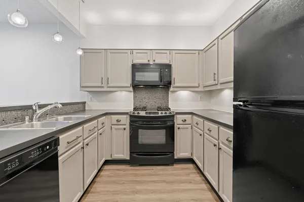 a kitchen with a sink stove and cabinets