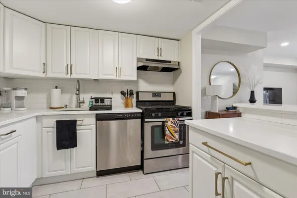 a kitchen with white cabinets and white appliances