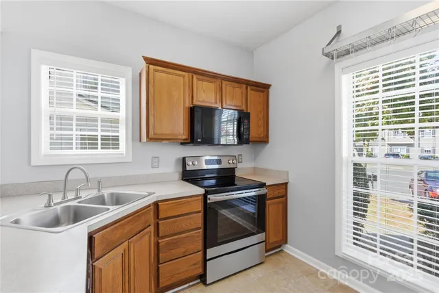 a kitchen with stainless steel appliances granite countertop a sink stove and microwave
