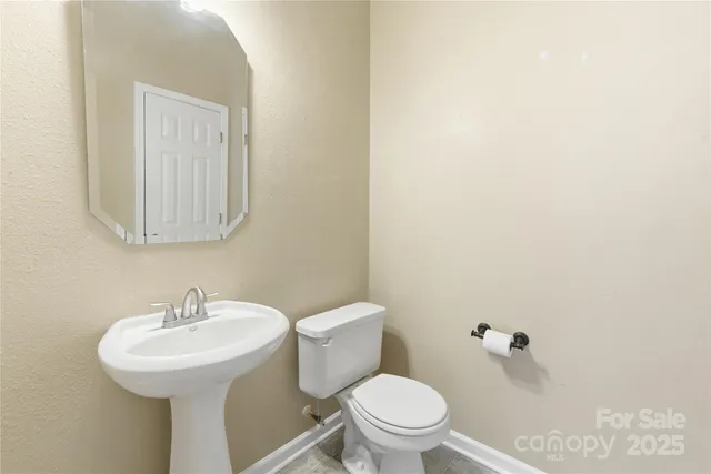 a bathroom with a toilet a sink and mirror