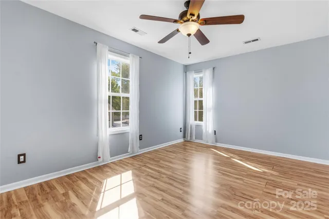 a view of a big room with wooden floor and windows in a room