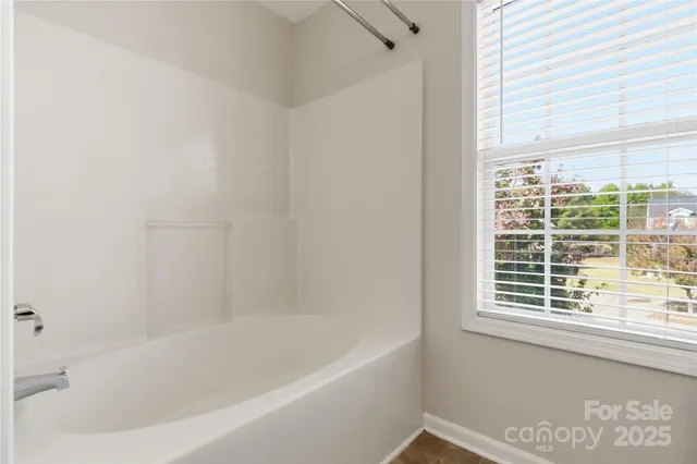 a bathroom with bathtub and window