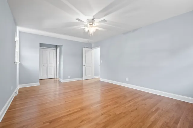 a view of an empty room with wooden floor