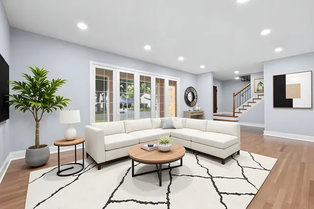 a living room with furniture potted plant and a large window