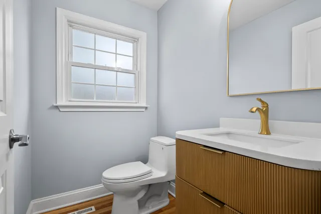 a bathroom with a sink a toilet and a window