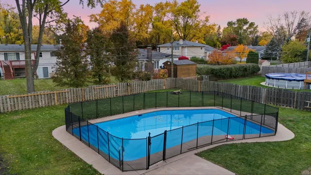 a view of a backyard with a small cabin and a wooden fence