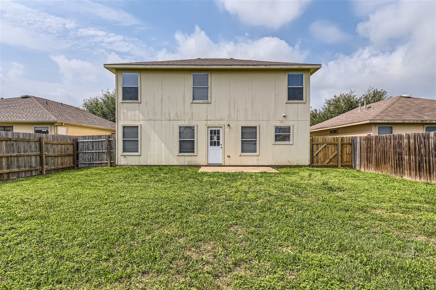 18408 Cloudmore Lane Elgin, TX 78621 - Photo 10 of 11 A well-maintained fenced yard frames this two-story residence, offering ample outdoor enjoyment.
