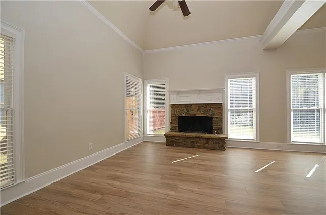 an empty room with floor to ceiling window and fireplace