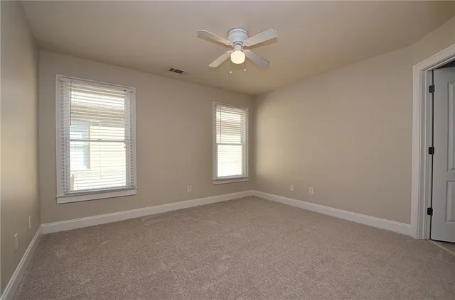 an empty room with a window and a ceiling fan