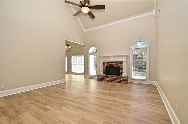 a view of an empty room with a fireplace and wooden floor