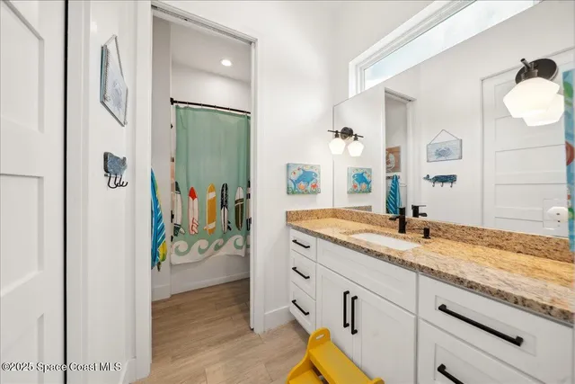 a bathroom with a granite countertop sink a toilet and a mirror