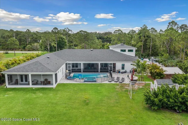 a aerial view of a house with a yard table and chairs