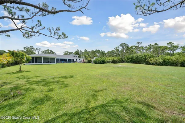 an empty room with wooden floor and ceiling fan