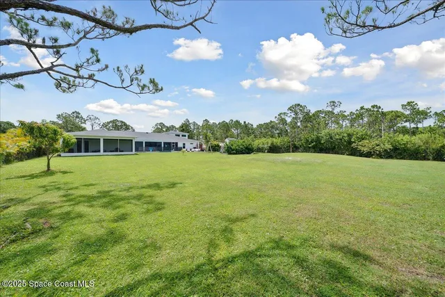 an empty room with wooden floor and ceiling fan