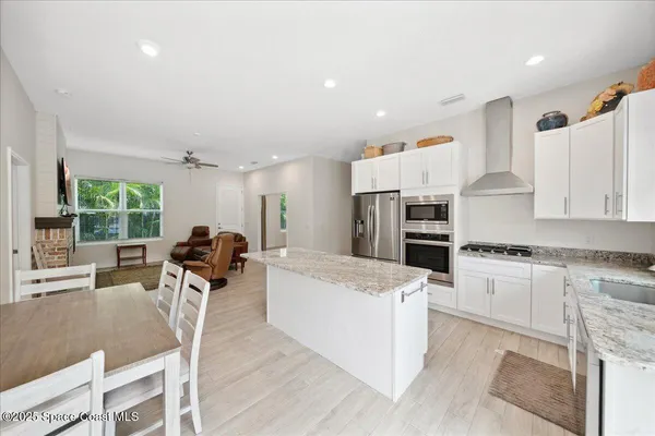 a view of a white house with a yard and potted plants
