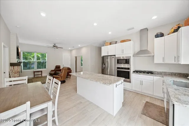 a view of a white house with a yard and potted plants