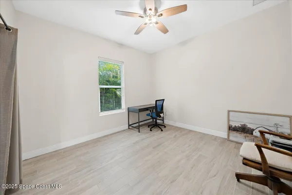 a front view of a house with a yard and potted plants