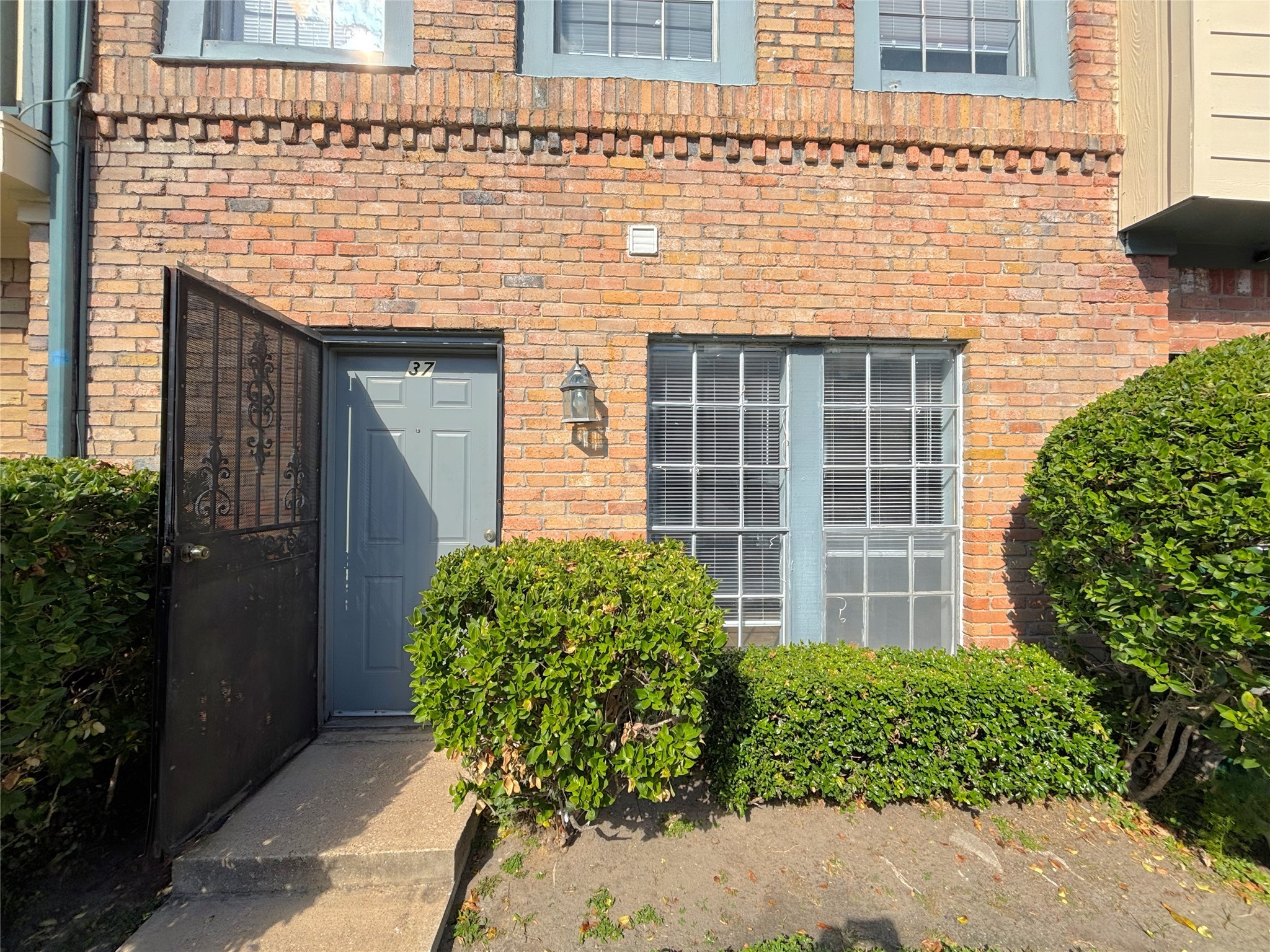 a view of a brick house with potted plants