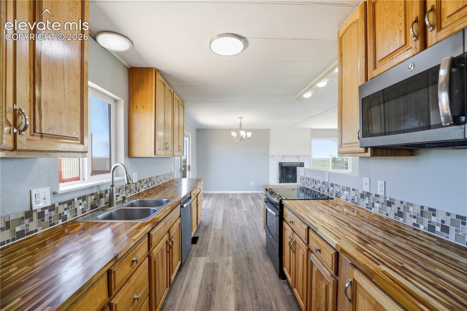 19027 Murphy Road Peyton, CO 80831 - Photo 10 of 49 Butcher Block, Open Concept, Vinyl Plank, Mud Space Through Kitchen, Dining Room Sliding Door Off Kitchen