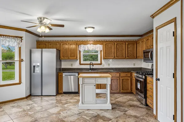 a kitchen with stainless steel appliances granite countertop a refrigerator oven a sink and dishwasher