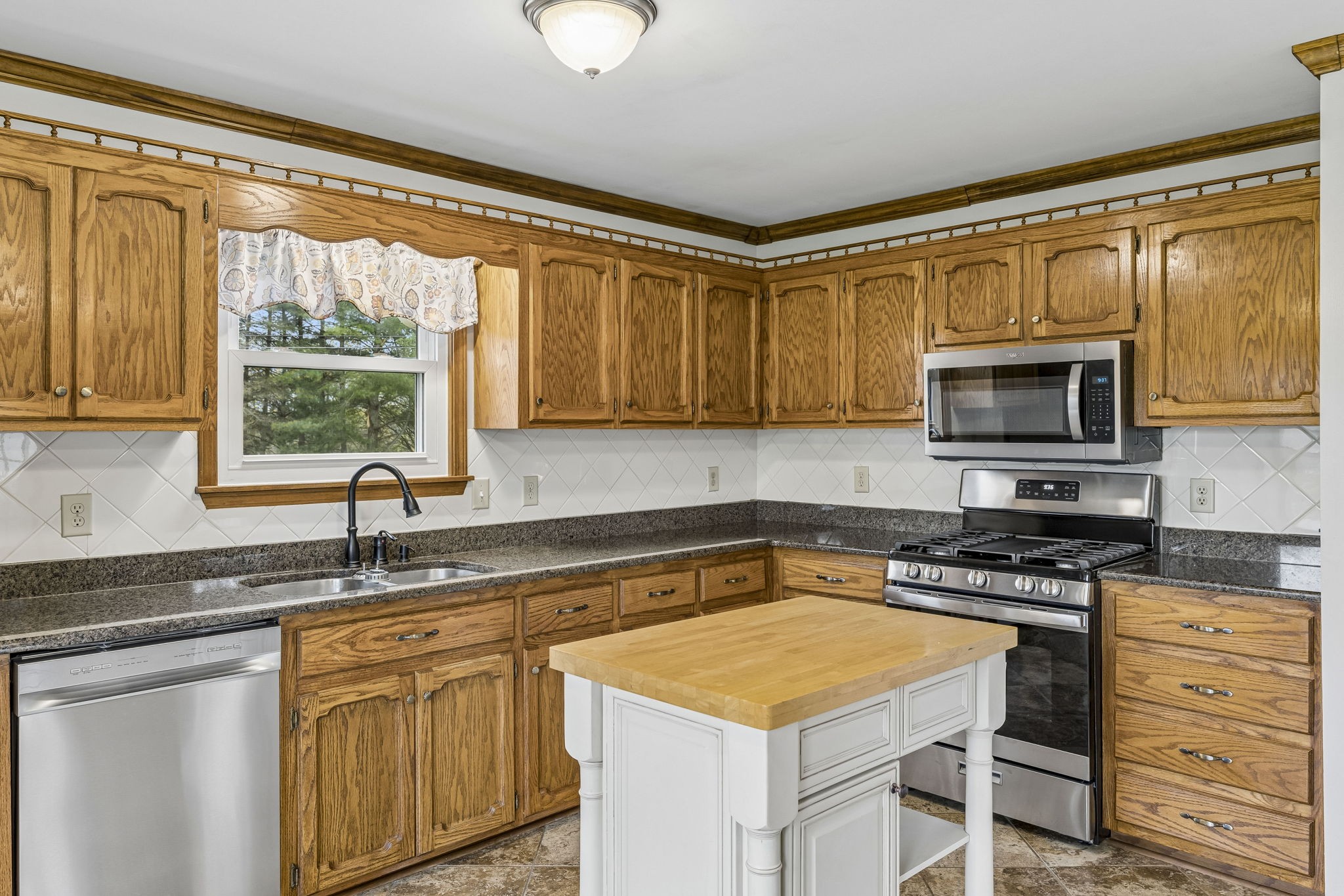 97 Oak Valley Drive Spring Hill, TN 37174 - Photo 23 of 40 a kitchen with granite countertop a sink appliances cabinets and a counter top space