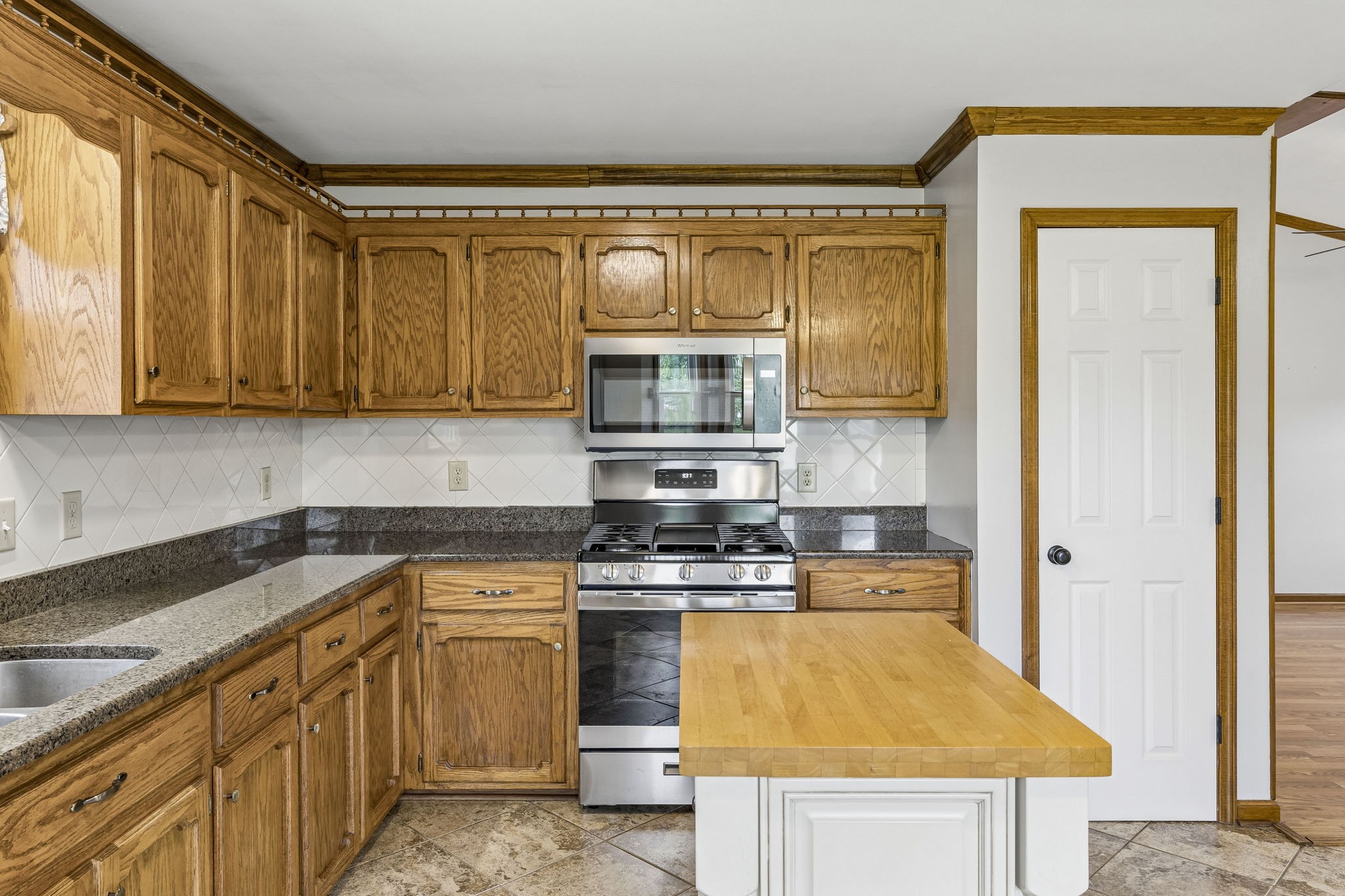 97 Oak Valley Drive Spring Hill, TN 37174 - Photo 24 of 40 a kitchen with kitchen island granite countertop a sink and a stove next to a window