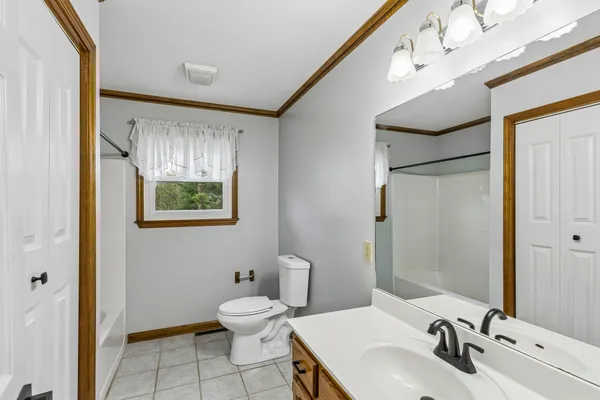 a bathroom with a toilet sink and mirror