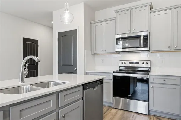 a kitchen with stainless steel appliances granite countertop a sink stove and microwave
