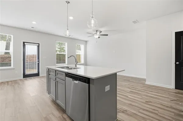 a kitchen with kitchen island a sink appliances and wooden floor