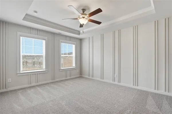 an empty room with windows and ceiling fan