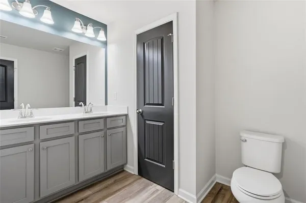 a bathroom with a toilet a sink and mirror