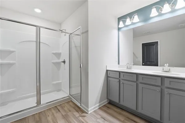 a bathroom with a double vanity sink mirror and shower