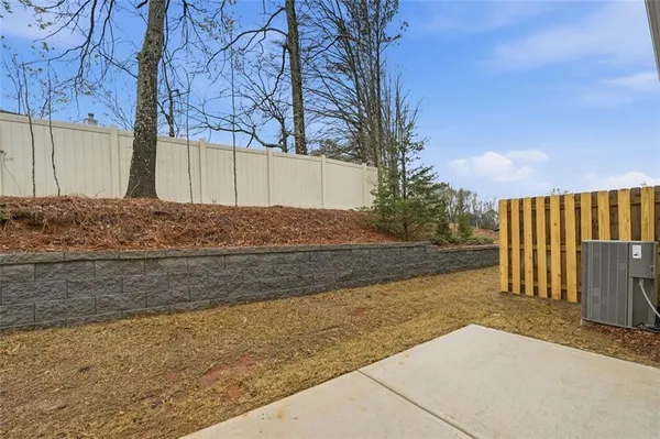 a view of backyard and wooden fence