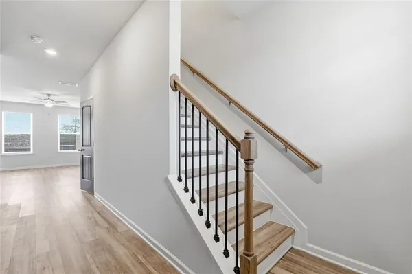 a view of a hallway with wooden floor and staircase