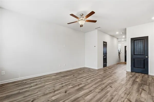 a view of a livingroom with a ceiling fan & wooden floor