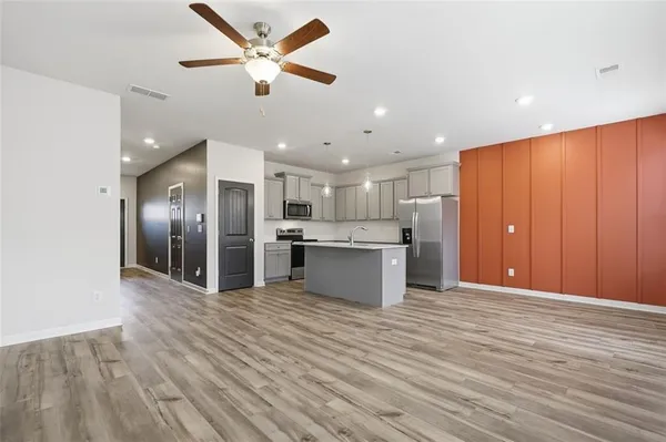 a view of kitchen with cabinets stainless steel appliances and a chandelier