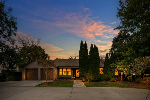 a front view of a house with a yard and tree s